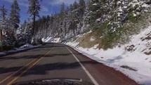 driving down a road lined by snowy hills 