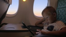 Bored kid with pad in plane