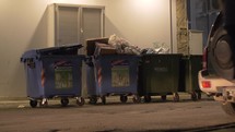 Town street with full dumpsters, view at night