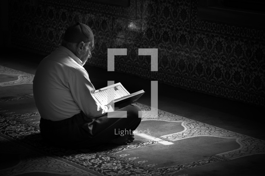 Elderly muslim man reading book