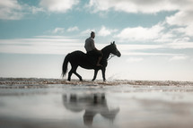 Horse riding on a beach, equestrian man riding on a horse