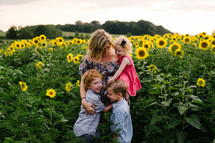 a mother and her children in a field of sunflowers 