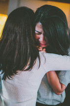 women hugging at a worship service 