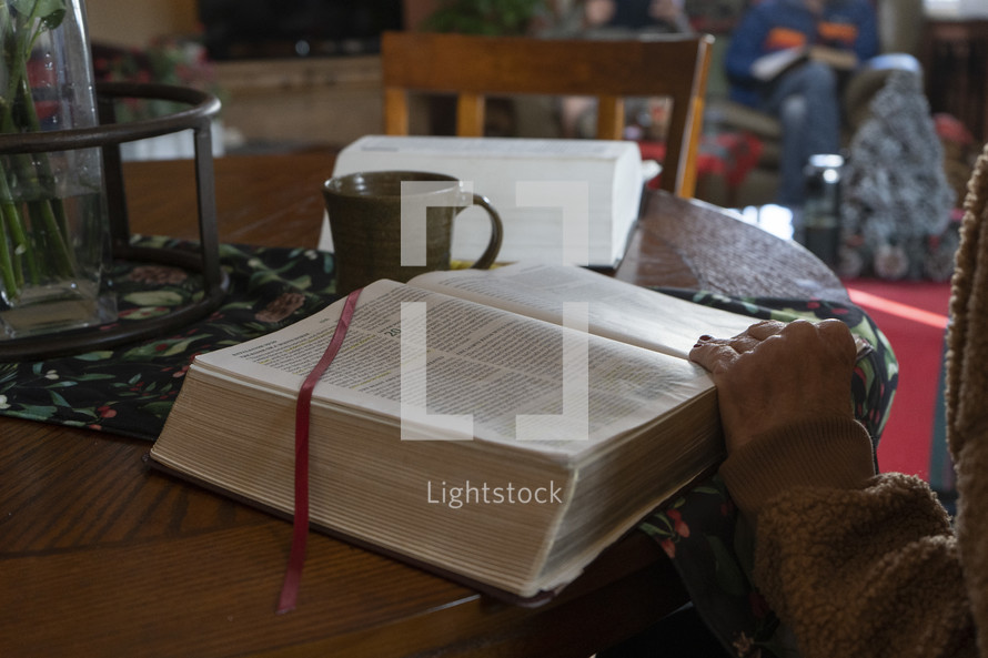 A woman looking up a Bible verse at a home study