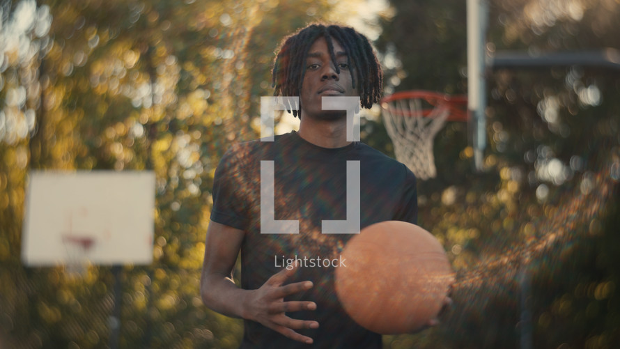 Portrait of a smiling young man playing basketball on a sunny day