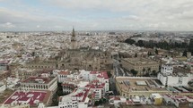 Main facade of Seville Cathedral, sprawling charming cityscape. Aerial view