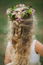 crown of flowers and berries in the hair of a flower girl