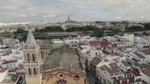 Aerial forward view of the city of Seville, its Guadalquivir river and the beautiful cathedral in background. Spain