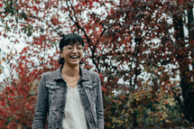 a woman laughing outdoors in autumn 