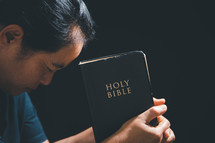 Asian person holding a Bible