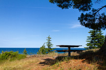 picnic table by a lake shore 