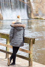 woman in a coat looking at water 