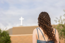 a teen girl looking at a church 