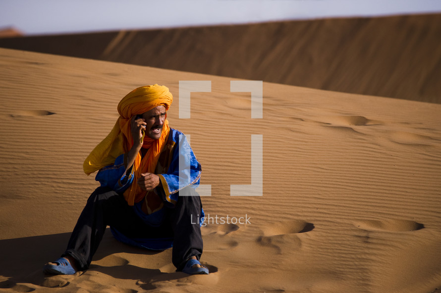 man sitting on sand dunes 