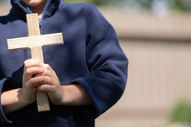 a boy holding a cross 