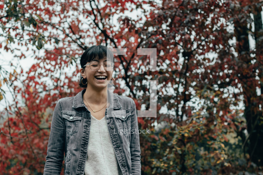 a woman laughing outdoors in autumn 