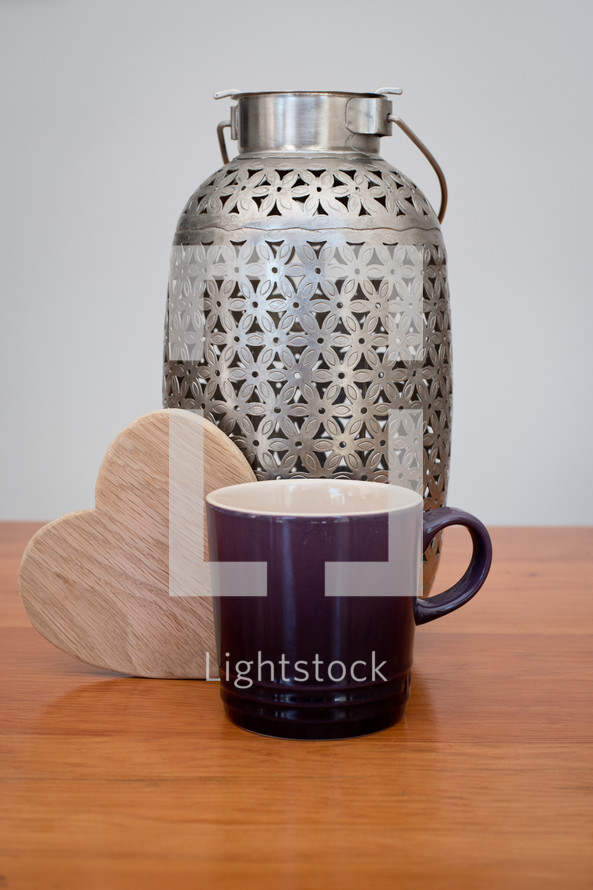 mug, wooden heart, and silver container 