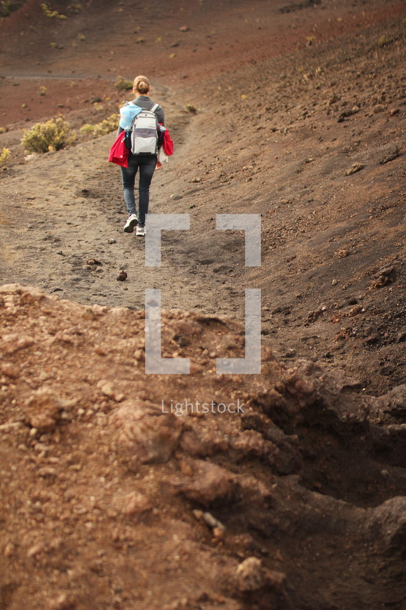 a woman hiking a path to a crater in Hawaii 