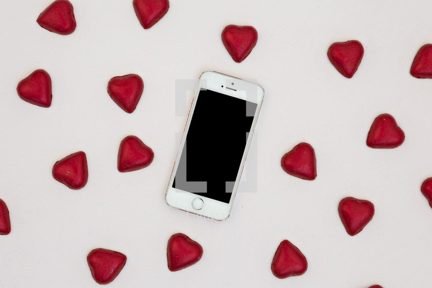 red heart shaped chocolates and cellphone 