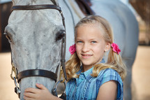 girl child in pig tails with a horse