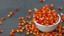candy corn dropping into a bowl 
