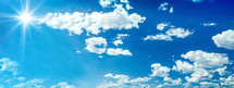 Clear blue sky with sun and clouds