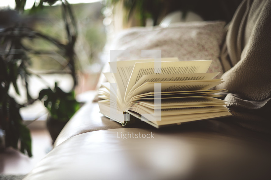 open pages of a book on a couch 