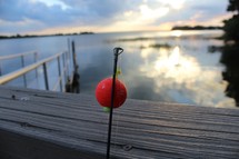a fishing pole at a lake pier 