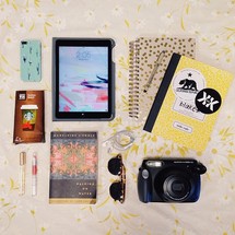 gift card, camera, novel, sunglasses, lipgloss, journal, iPad, iPhone, pen, and earbuds 