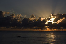 sunrise and rays through the clouds over the ocean