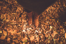 a woman standing in fall leaves 