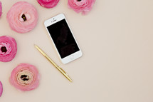 pink peonies, cellphone, and gold pen 