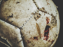 White soccer ball with blood, mud, and scratches