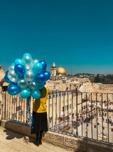 a woman holding balloons in Jerusalem 