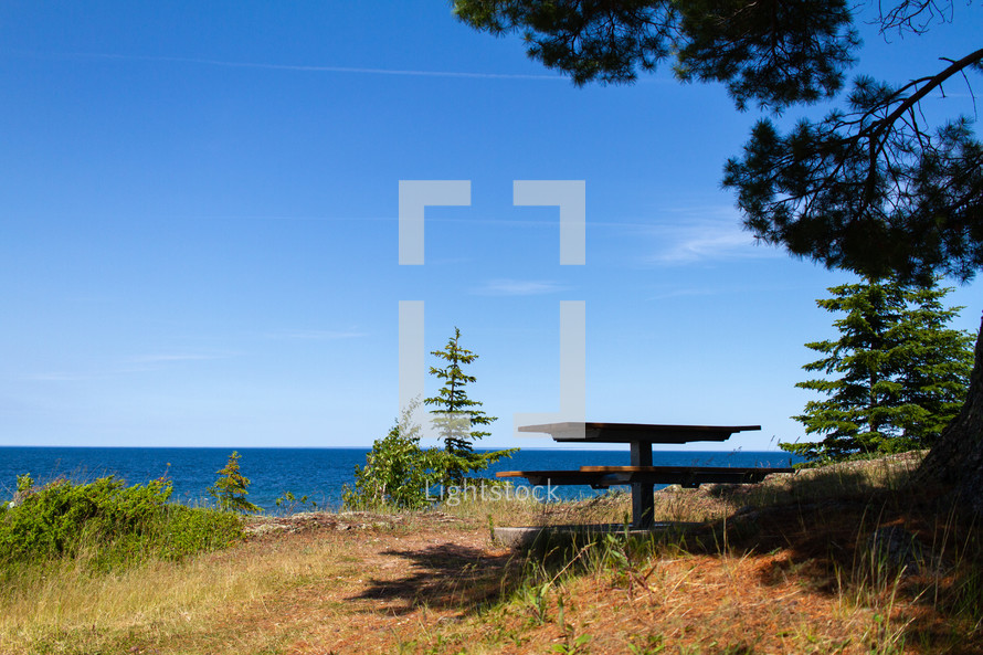 picnic table by a lake shore 