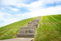 Concrete staircase going up over grassy hill horizontal
