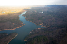 Aerial view from airplane of river water and mountainous forest land