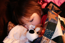 sleeping child snuggling with a stuffed animal 