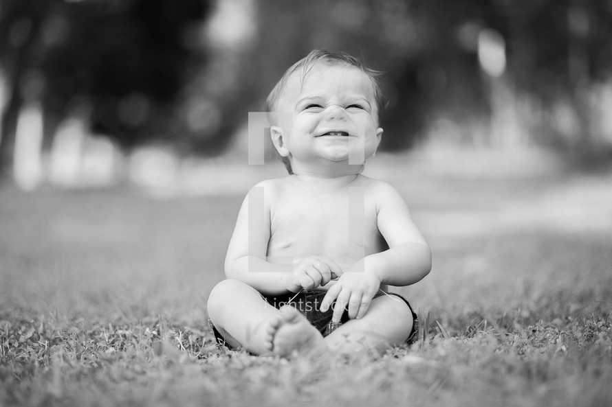 happy baby sitting in a field