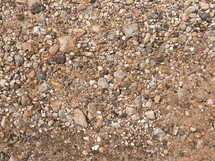 small rocks on sandy ground, natural colors