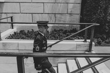 a soldier in uniform walking up steps 