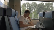 Man using laptop during ride in commuter train