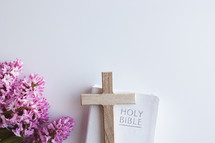 Pink hyacinth flowers with cross and Bible on a white background