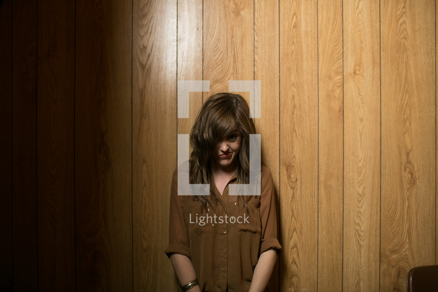 Woman standing in front of wood panel