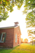 Upward view of old brick one room schoolhouse surrounded by trees in Ohio  