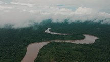 Drone aerial view of a narrow river in a dense rainforest in Ecuador.