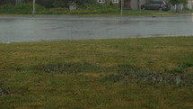 Rain coming down on front lawn in suburban neighbourhood-slider shot