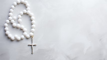 Crucifix rosary on white background with copy space