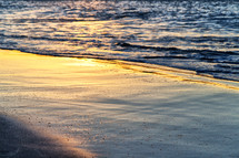 sunlight on wet sand on a beach 