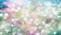 soft bokeh blur of heart shapes in pink, white, blue with darker blue edges